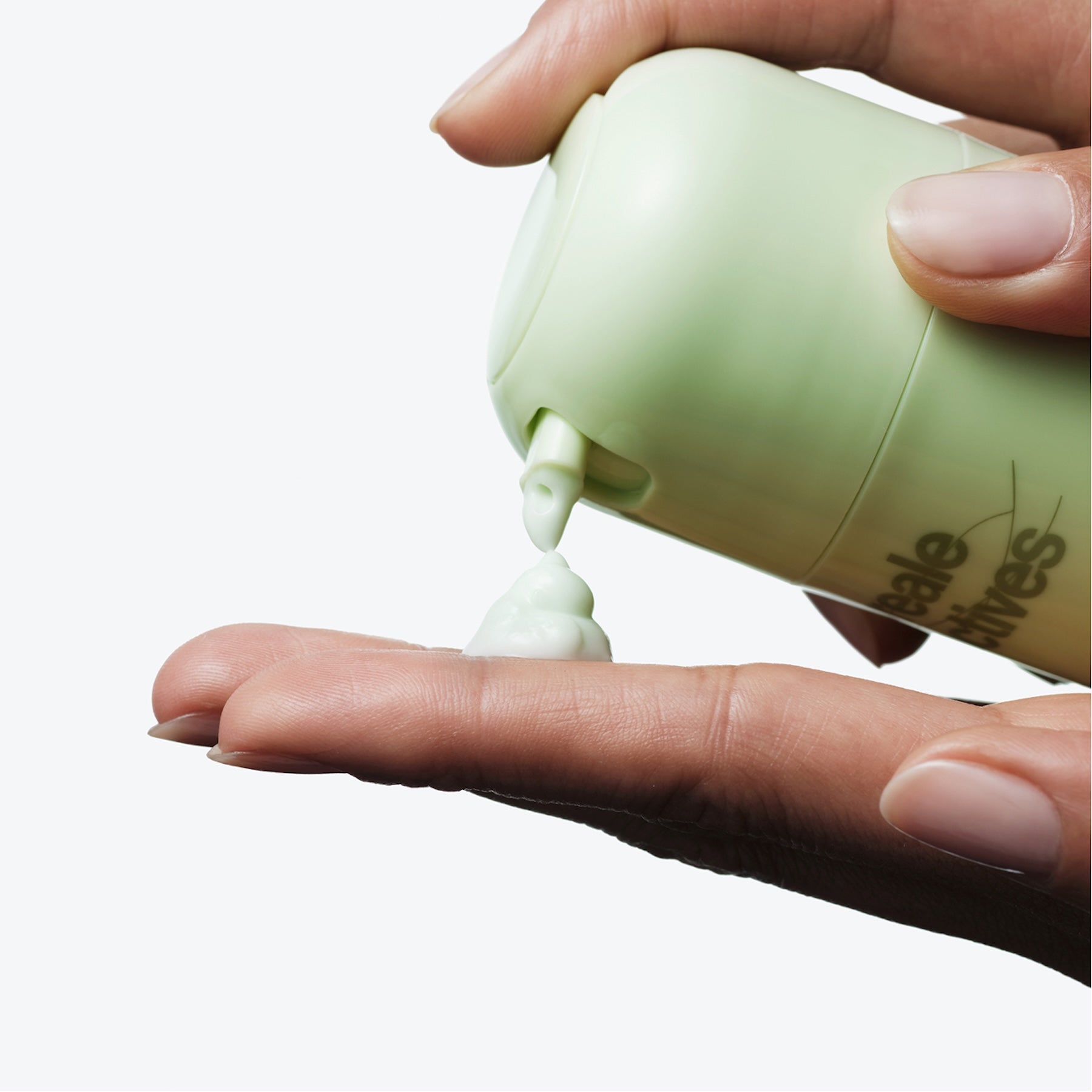 Hand holding Dew More Reale Actives with cream being applied to the palm.